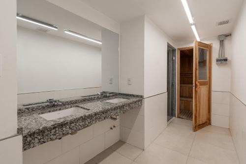 a bathroom with two sinks and a mirror at Departamento un ambiente Premium Puerto Norte Rosario in Rosario