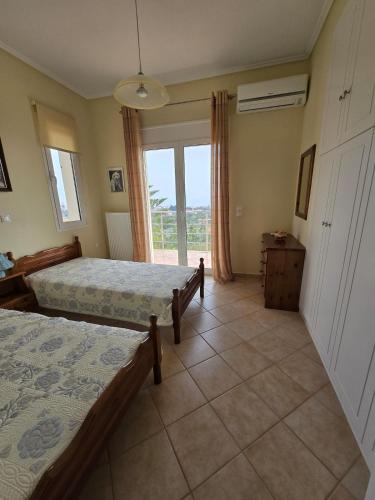 a bedroom with two beds and a large window at Villa Sea View in Chios