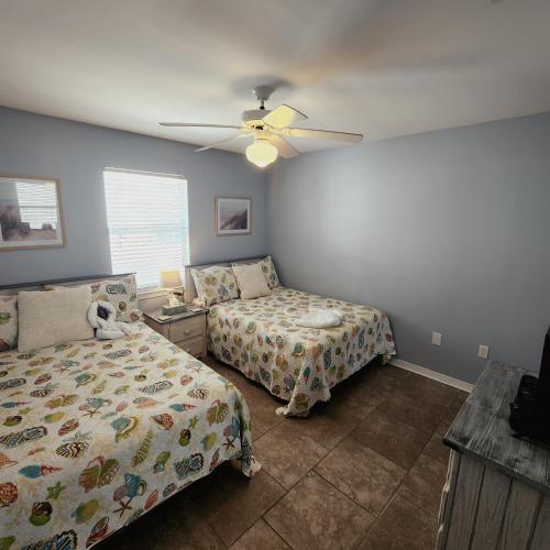 a bedroom with two beds and a ceiling fan at Condo in Gulf Shores King Suite in Gulf Shores