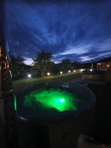 a hot tub with green water at night at LiAn House in Corbeni