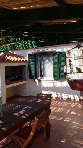 a patio with a wooden bench and a bird cage at Big Two-Storey House up to 8 person in Ayía Sofía