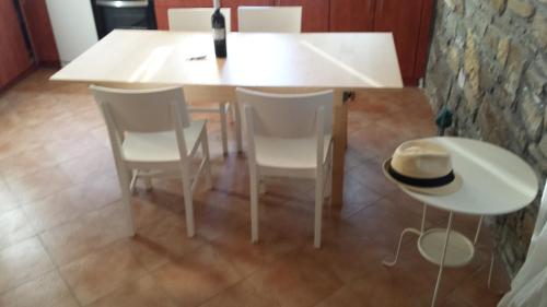 a white table and chairs with a hat on it at Big Two-Storey House up to 8 person in Ayía Sofía