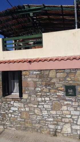 a stone building with a window on it at Big Two-Storey House up to 8 person in Ayía Sofía