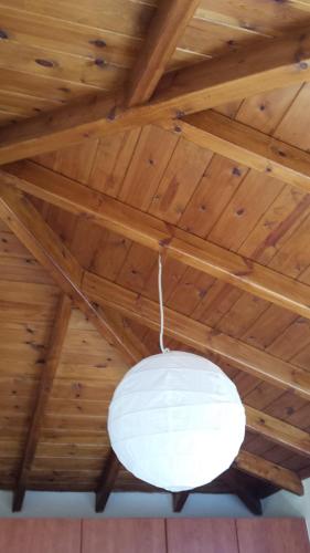 a white light hanging from a wooden ceiling at Big Two-Storey House up to 8 person in Ayía Sofía