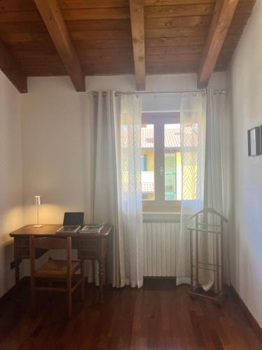 a room with a desk and a window with a laptop at Casa Davide in Castelnuovo del Garda
