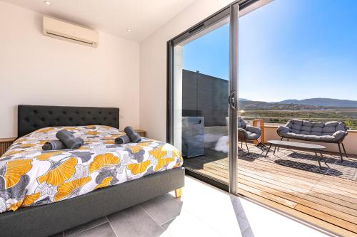 une chambre avec un lit et un balcon dans l'établissement Ô Loupiots - joli duplex climatisé à Porticcio, à Grosseto-Prugna