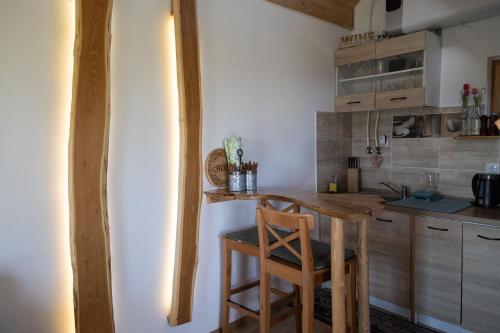 a small kitchen with a wooden table and chairs at Balatoni Présházikó in Szőlősgyörök