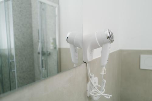 a hair dryer is hanging on the wall of a bathroom at Ventus Park Hotel in Nago-Torbole