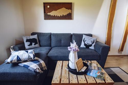 a living room with a blue couch and a coffee table at Balatoni Présházikó in Szőlősgyörök