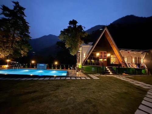 デヘラードゥーンにあるThe Brookside Bungalowの家の前にプールがある家