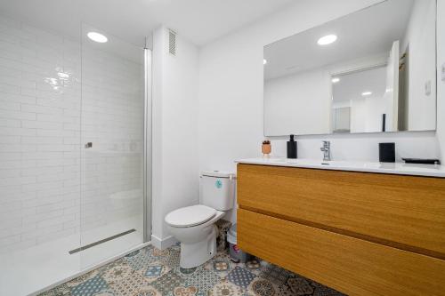 Un baño con inodoro, lavabo y ducha. en Apartamento TECAVI II, en La Pineda