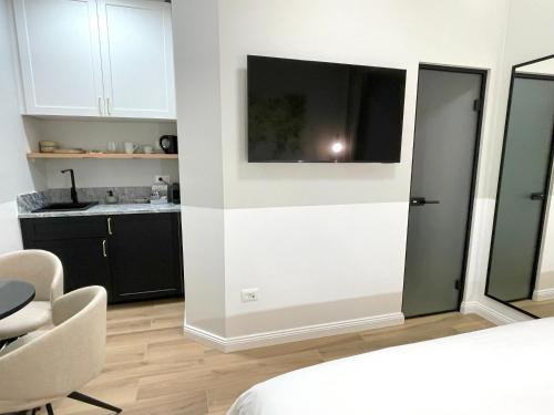 a room with a bed and a kitchen with a tv on the wall at Olive Rooms in Zadar