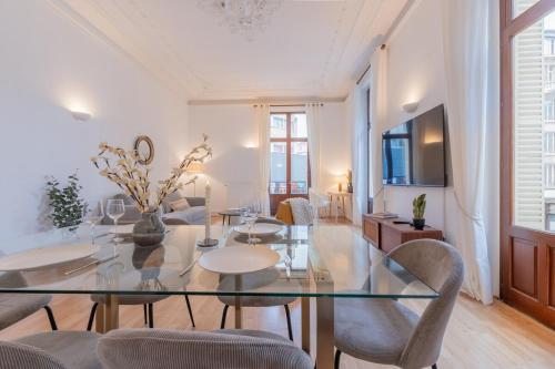 une salle à manger avec une table et des chaises en verre dans l'établissement Le Saint Jean - Vue - Centre - Gare - 5 pers, à Nancy