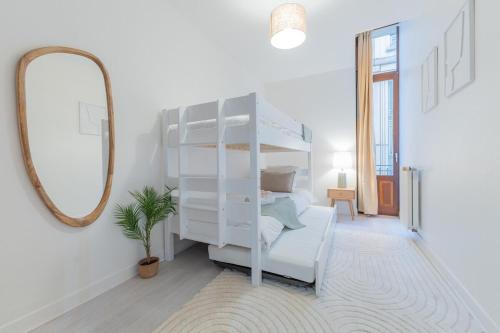 une chambre blanche avec un miroir et un lit superposé blanc dans l'établissement Le Saint Jean - Vue - Centre - Gare - 5 pers, à Nancy