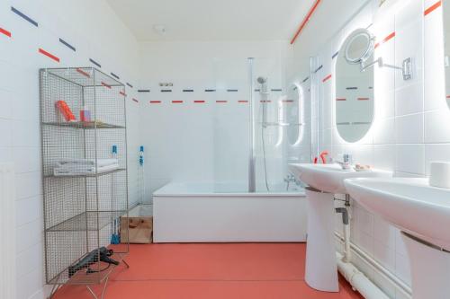 une salle de bain blanche avec une baignoire et un lavabo dans l'établissement Le Saint Jean - Vue - Centre - Gare - 5 pers, à Nancy