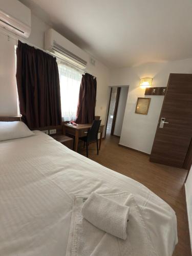 a hotel room with a white bed and a desk at Slimiza Suites in Sliema