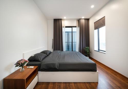a bedroom with a large bed and a wooden floor at Luxe Paradise Residence Trinh Cong Son in Hanoi