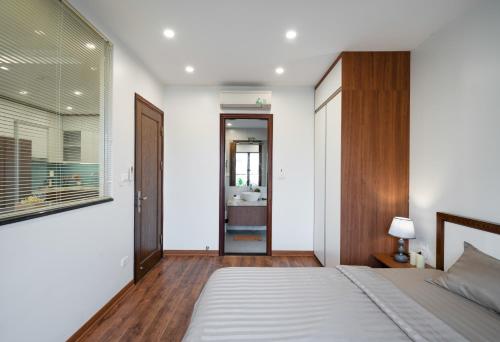 a bedroom with a large bed and a bathroom at Luxe Paradise Residence Trinh Cong Son in Hanoi