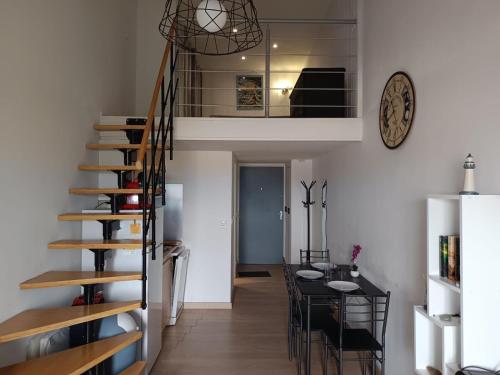 - un escalier dans une pièce avec une table et une salle à manger dans l'établissement EN VENDEE à saint hilaire de riez DUPLEX 4/6pers, à Saint-Hilaire-de-Riez