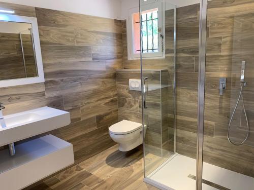 une salle de bain avec toilettes et douche en verre dans l'établissement Villa Marina di Fiori, à Porto-Vecchio