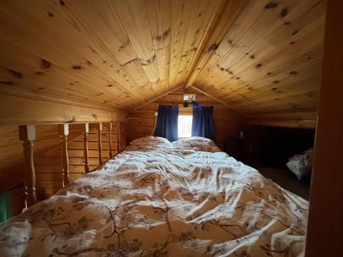 Una cama grande en una habitación con techo de madera. en Cabin with an entire island to itself, en Mariehamn