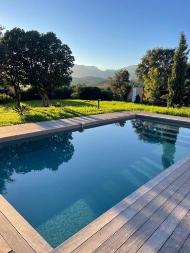 - une piscine avec une terrasse en bois et de l'eau bleue dans l'établissement Villa Marina di Fiori, à Porto-Vecchio
