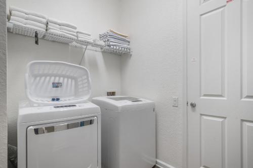 a small white laundry room with a washer and dryer at Orlando Resort Rentals at Universal Boulevard in Orlando