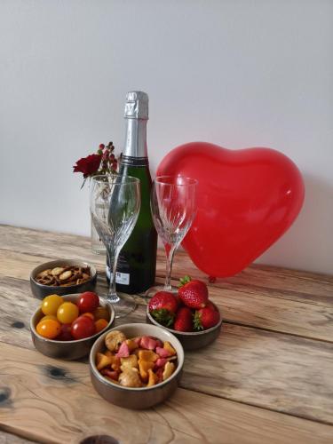 - une table avec une bouteille de vin et des bols de fruits dans l'établissement La Rêverie, à Rezé