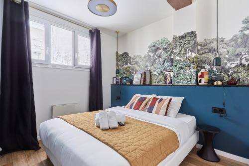 une chambre avec un lit avec un mur bleu dans l'établissement Duplex in the center of Paris, à Paris