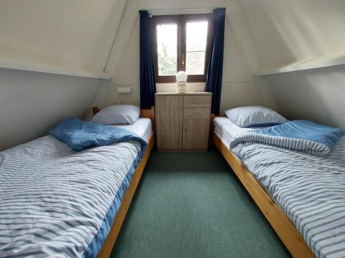 two twin beds in a room with a window at Chalet 230 I Gezellig chalet aan de rand van het bos - 5 persoons I Durbuy in Durbuy