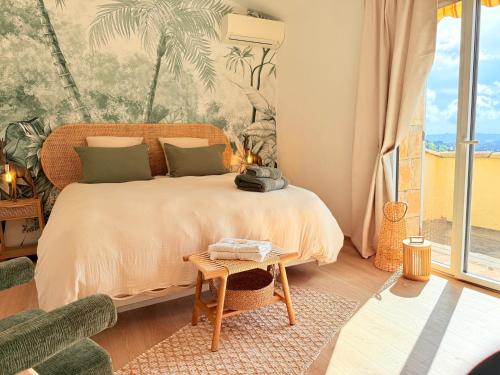 une chambre avec un lit avec une grande fenêtre dans l'établissement Villa Plen Souleù - Vue époustouflante - Luxe et authenticité, à Cabris