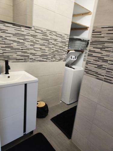 une salle de bain avec un lavabo et une poubelle dans l'établissement Maison de vacances proche Saint gilles x de vie, à Coëx