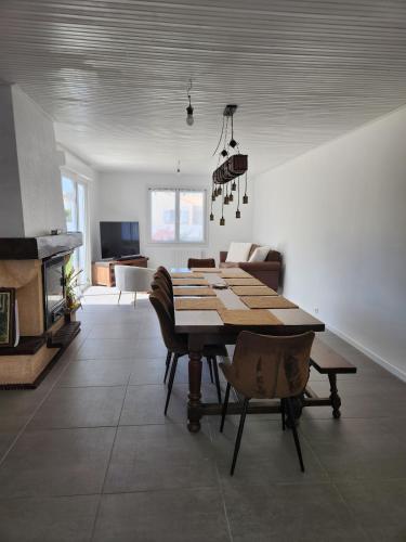 une salle à manger avec une table et des chaises en bois dans l'établissement Maison de vacances proche Saint gilles x de vie, à Coëx