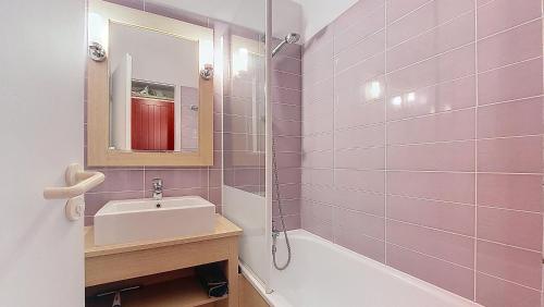 une salle de bain rose avec un lavabo et un miroir dans l'établissement M- Albatros 04-Moliets Appartement 2 pièces avec terrasse proche golf, à Moliets-et-Maa
