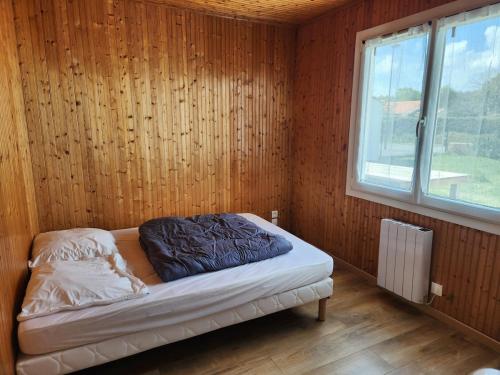 Cette chambre en bois dispose d'un lit et d'une fenêtre. dans l'établissement Maison de vacances proche Saint gilles x de vie, à Coëx
