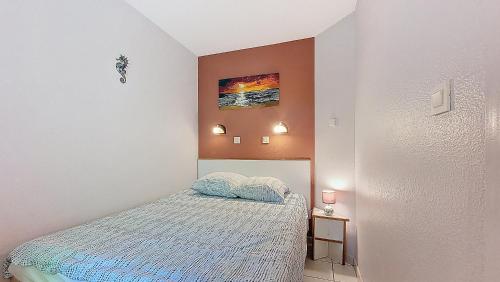 une chambre avec un lit et un tableau au mur dans l'établissement M- Albatros 04-Moliets Appartement 2 pièces avec terrasse proche golf, à Moliets-et-Maa