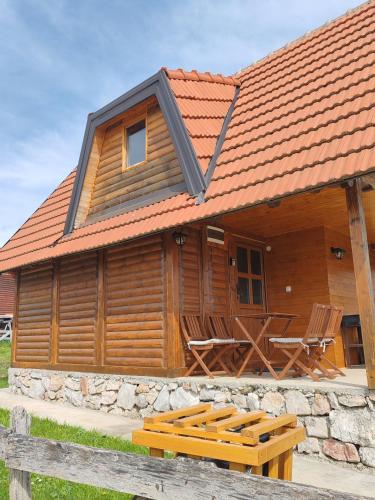 a log cabin with a porch and a roof at vikendica tarska car in Mitrovac