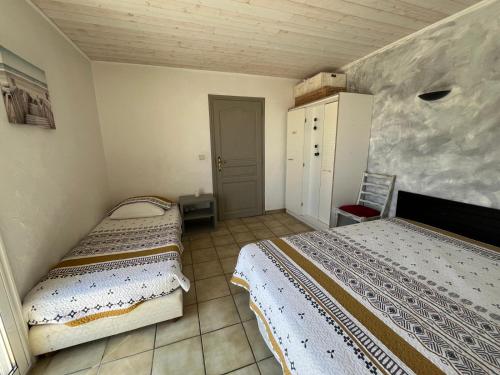 une chambre avec deux lits dans une pièce dans l'établissement L'éveil Marin, à Roquebrune-sur Argens