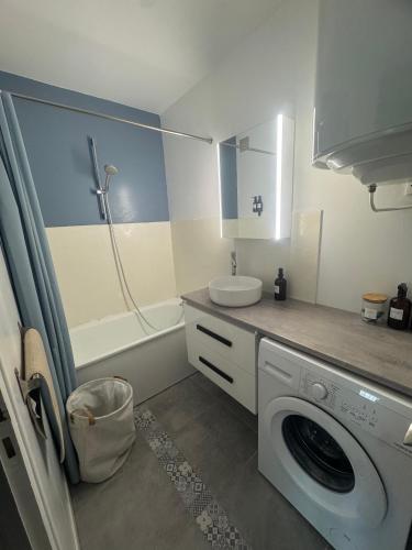 une salle de bain avec une machine à laver et un lavabo dans l'établissement L'Échappée Vendéenne - T2 cosy en bord de mer, à Saint-Hilaire-de-Riez