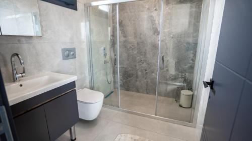 a bathroom with a shower and a toilet and a sink at Selimiye Mia Villa's in Selimiye