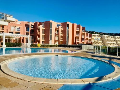 une grande piscine devant un immeuble dans l'établissement ''578'' Superbe T2 Front de mer, Parking, Clim, à Sète