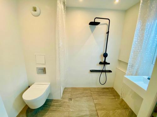 a white bathroom with a toilet and a sink at ''578'' Superbe T2 Front de mer, Parking, Clim in Sète
