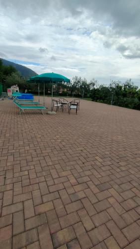 two picnic tables and an umbrella on a brick patio at La tenuta di Eva in Pisa