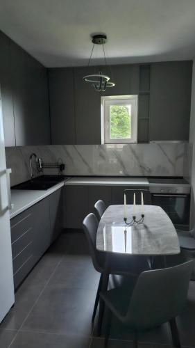 a kitchen with a table and chairs and a sink at Nuko's family in Nikšić