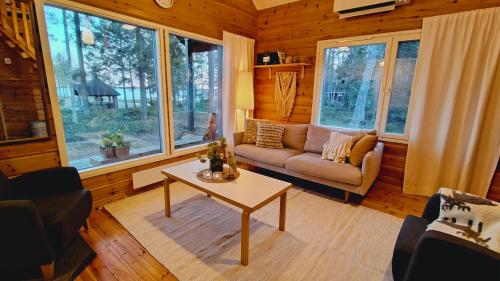 a living room with a couch and a table at Villa Dyyni - Oulujärvi Manamansalo in Vaala