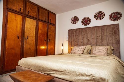 una camera da letto con un letto grande e due piatti sul muro di KIMI Home a Douala