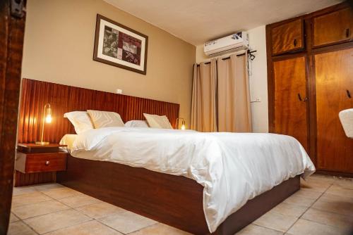 una camera da letto con un letto grande con testiera in legno di KIMI Home a Douala