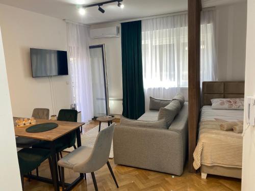 a living room with a bed and a couch and a table at Apartman MM Vrnjacka Banja in Vrnjci