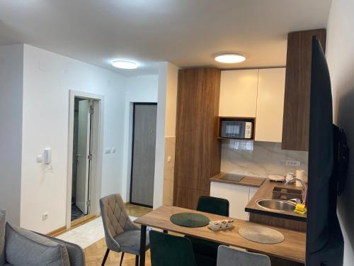a kitchen with a table and chairs in a room at Apartman MM Vrnjacka Banja in Vrnjci