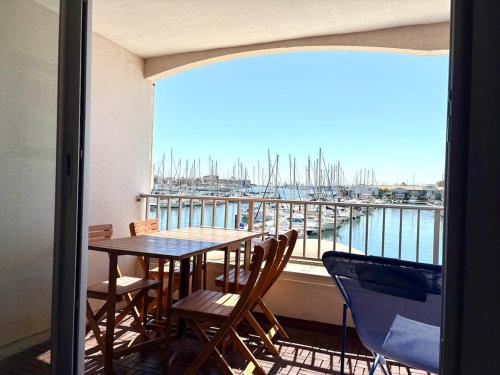 d'un balcon avec une table et des chaises et une vue sur le port de plaisance. dans l'établissement Appartement - Cap d'Agde, au Cap d'Agde